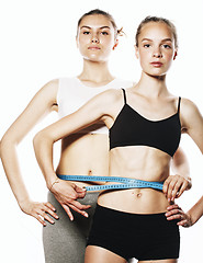 Image showing two sport girls measuring themselves isolated on white