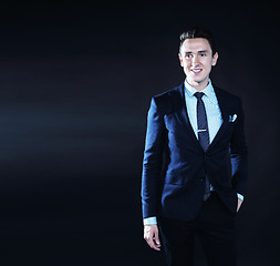 Image showing young pretty business man standing on black background, modern h