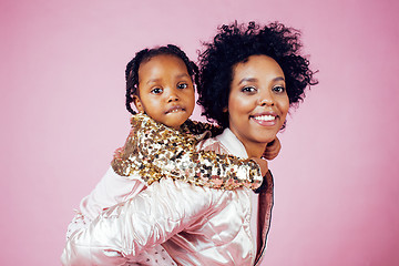 Image showing young pretty african-american mother with little cute daughter hugging, happy smiling on pink background, lifestyle modern people concept 