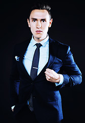 Image showing young pretty business man standing on black background, modern h