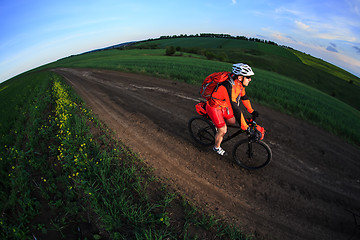 Image showing Tourist with backpack travels by bicycle