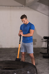 Image showing man workout with hammer and tractor tire