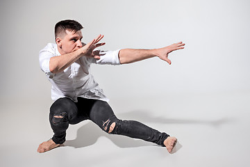 Image showing The young man dancing on gray