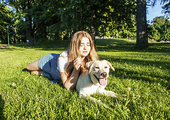 Image showing young attractive blond woman playing with her dog in green park at summer, lifestyle people concept