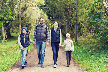 Image showing happy family with backpacks hiking in woods