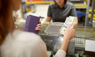 Image showing woman paying money at store cash register