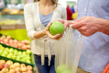 Image showing close up of couple buying apples at grocery store