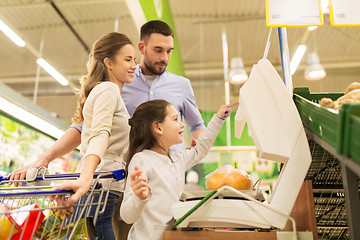 Image showing family weighing oranges on scale at grocery store