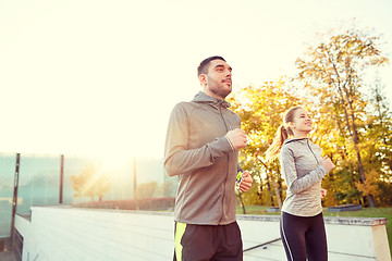 Image showing happy couple running upstairs on city stairs