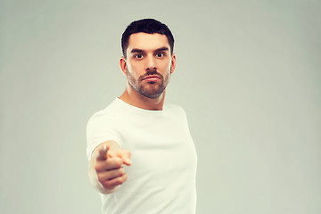 Image showing angry man pointing finger to you over gray