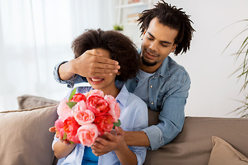 Image showing happy couple with bunch of flowers at home