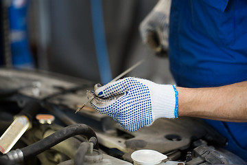 Image showing mechanic with dipstick checking motor oil level