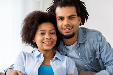 Image showing happy couple sitting on sofa and hugging at home