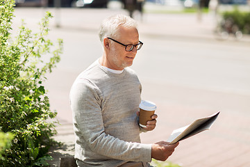 Image showing senior man reading newspaper and drinking coffee