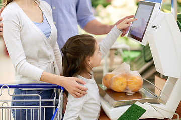 Image showing family weighing oranges on scale at grocery store