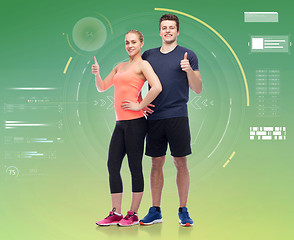 Image showing happy sportive man and woman showing thumbs up