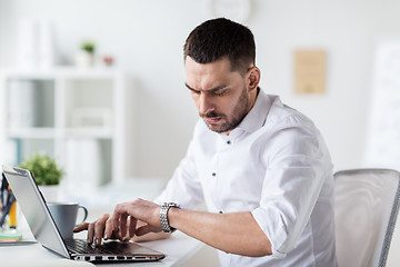 Image showing businessman with laptop and wristwatch at office