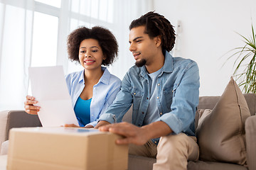 Image showing happy couple with parcel box and paper form home