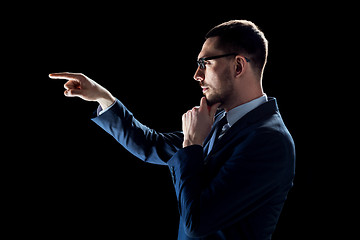 Image showing businessman in suit over black