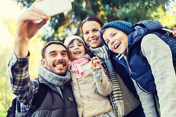 Image showing family with backpacks taking selfie by smartphone