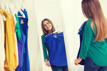 Image showing happy woman choosing clothes at home wardrobe