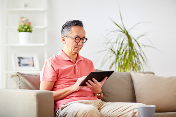 Image showing man with tablet pc sitting on sofa at home