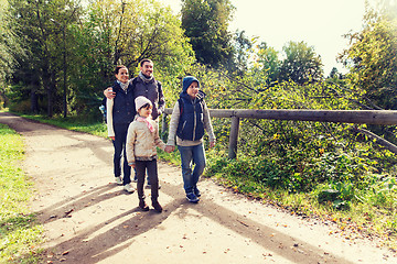 Image showing happy family with backpacks hiking in woods