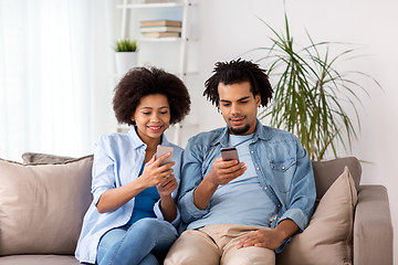 Image showing happy couple with smartphones at home