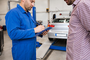 Image showing auto mechanic with clipboard and man at car shop