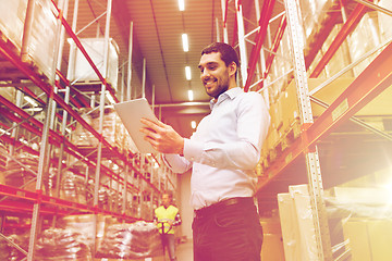 Image showing happy businessman with tablet pc at warehouse