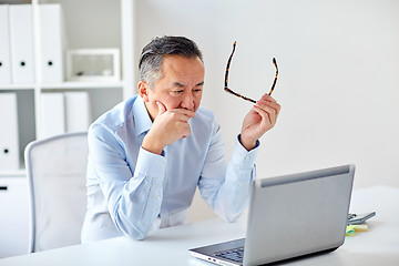 Image showing businessman with eyeglasses and laptop at office