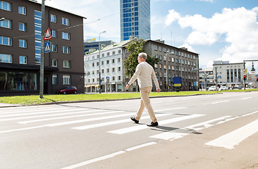 Image showing senior man walking along city crosswalk