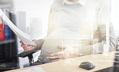 Image showing pregnant businesswoman reading papers at office