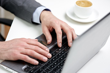 Image showing close up of male hands with laptop and coffee cup