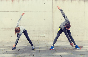 Image showing couple stretching on city street