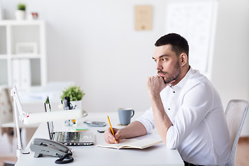 Image showing businessman with laptop and notebook at office