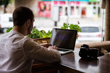 Image showing Photographer working on a laptop