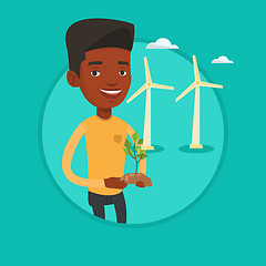 Image showing Worker of wind farm holding green small plant.