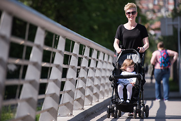 Image showing mother pushed her baby daughter in a stroller