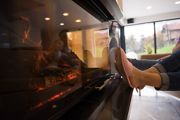 Image showing Young multiethnic couple  in front of fireplace