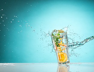 Image showing The rose exotic cocktail and fruit on blue