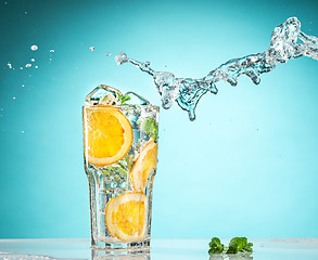 Image showing The rose exotic cocktail and fruit on blue