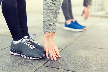 Image showing close up of couple stretching on city street