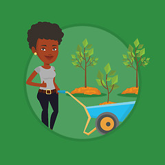 Image showing Woman pushing wheelbarrow with plant.