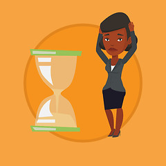 Image showing Desperate business woman looking at hourglass.