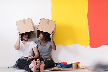 Image showing young multiethnic couple playing with cardboard boxes