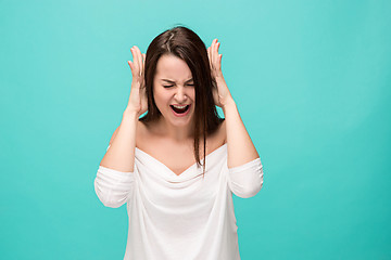 Image showing Frustrated young woman posing on blue