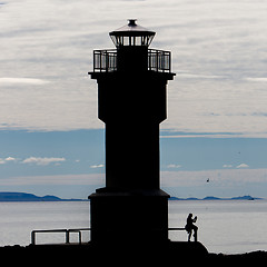 Image showing Seascape at sunset with a lighthouse