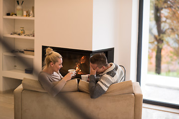 Image showing Young couple  in front of fireplace