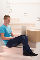 Image showing young man sitting in stairway at home